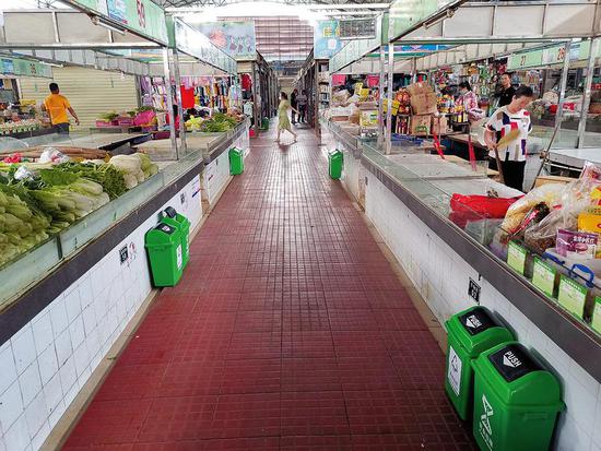 在高峰农贸市场，每个摊位前都摆放有分类垃圾桶。 南宁日报记者阮晓莹&nbsp;&nbsp;&nbsp;&nbsp;摄