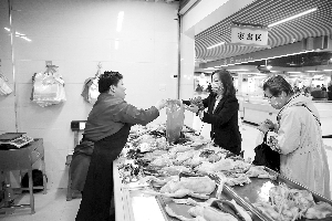 昨日,在红谷滩沁园农贸市场,市民在干净、整洁的环境中购买鸡、鸭等家禽类食品。余经纬 记者 马悦 摄