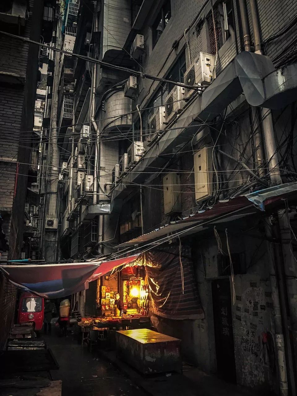 大年初四早上，四川达州的菜市场，一盏黄灯点亮了摊贩们的生活。/图虫