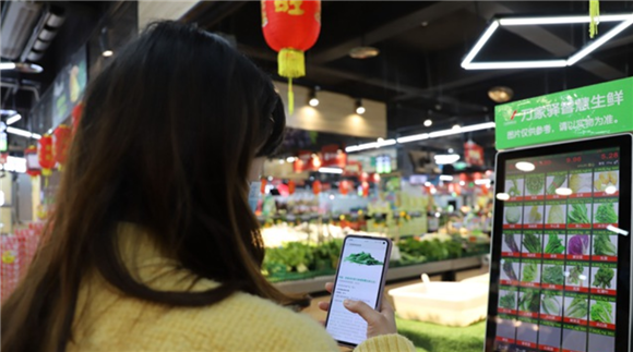 2顾客通过扫描称票上的二维码查看溯源信息。通讯员 谭启云 摄